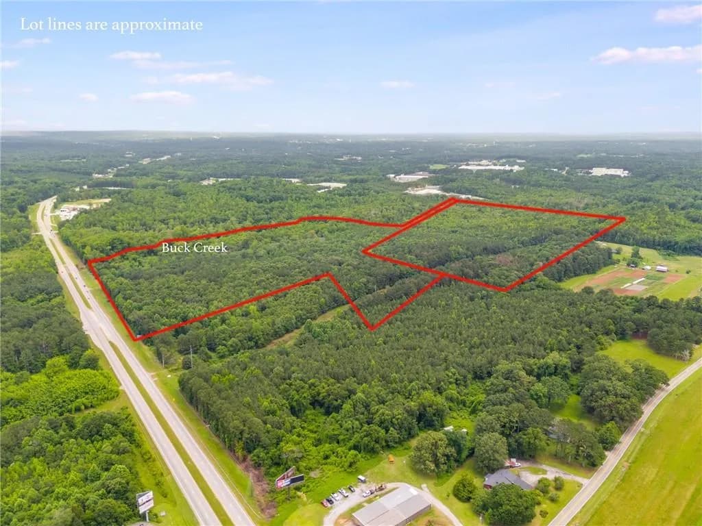 Aerial view of property's location with a forest and property parcel outlined