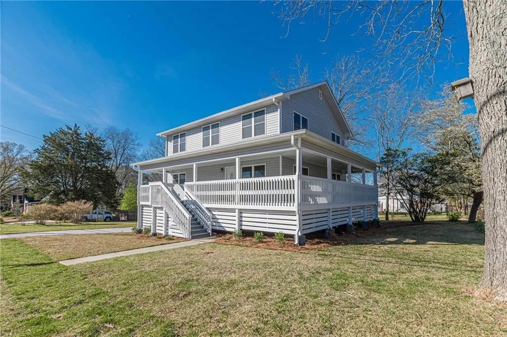View of front of property featuring an outbuilding, a front yard, a porch, and a ceiling fan
