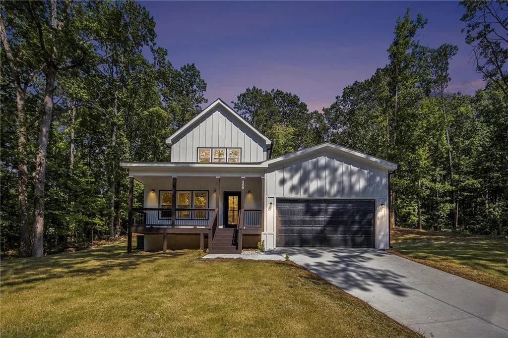 Modern farmhouse style home featuring covered porch, board and batten siding, a yard, and driveway