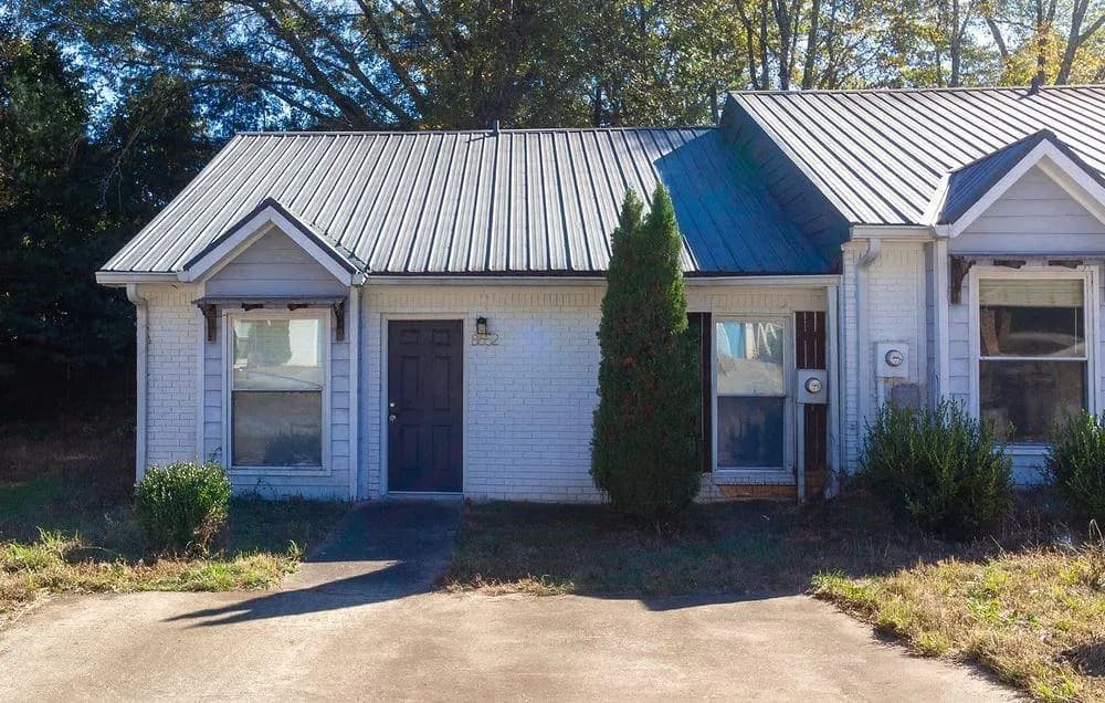 View of front of home with brick siding and a metal roof