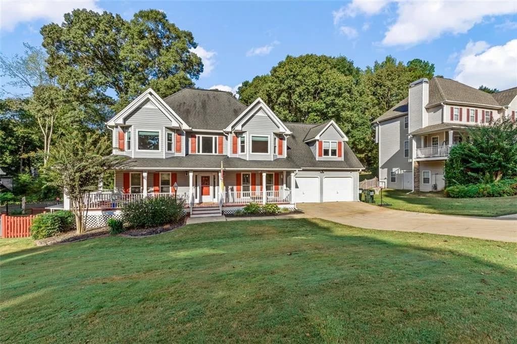 View of front of property with a front lawn, a porch, concrete driveway, and a garage