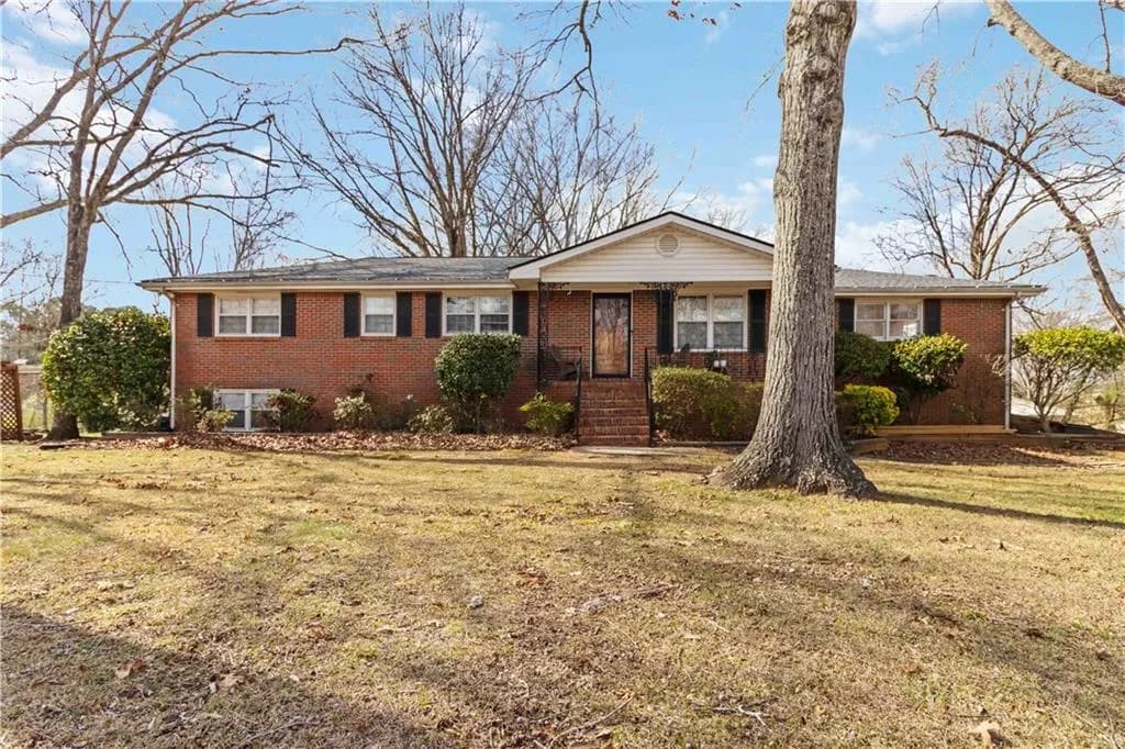 Single story home featuring brick siding and a front yard